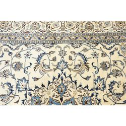 Central Persian Nain hand-knotted carpet, ivory field with central radiating medallion, issuing an all-over design of scrolling vines, palmettes, and delicate floral sprays with conforming spandrels, enclosed by a foliate border, framed by multiple guard stripes, with cotton fringe ends 