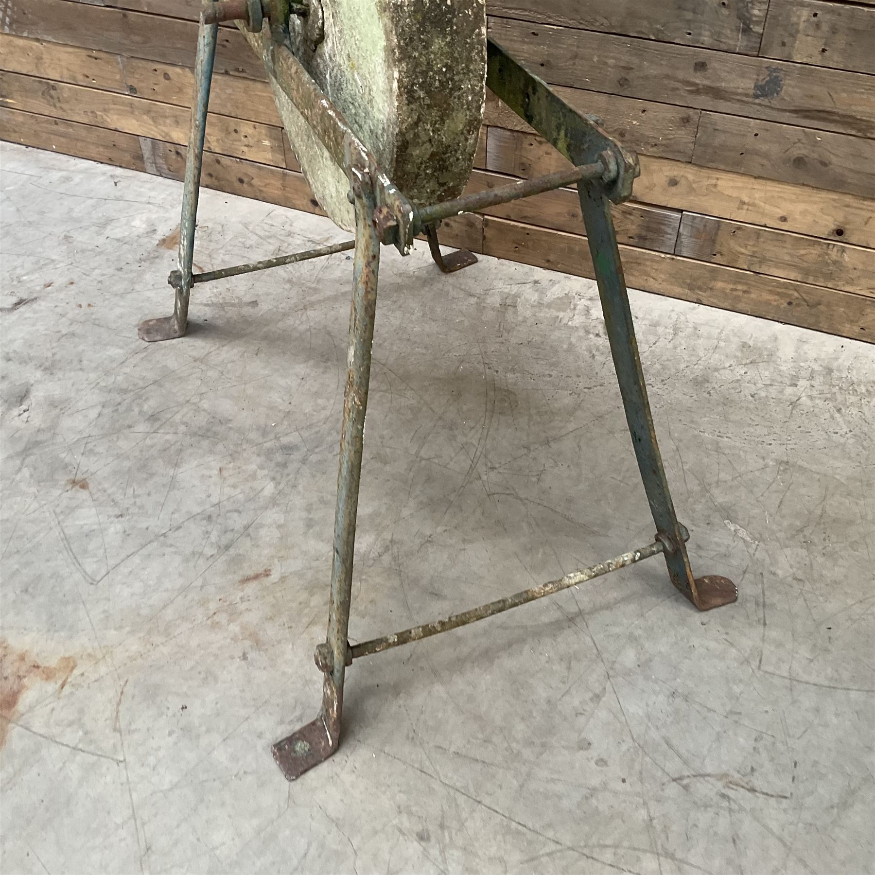 Vintage grindstone sharpening wheel mounted on metal stand, and a cast iron water pump