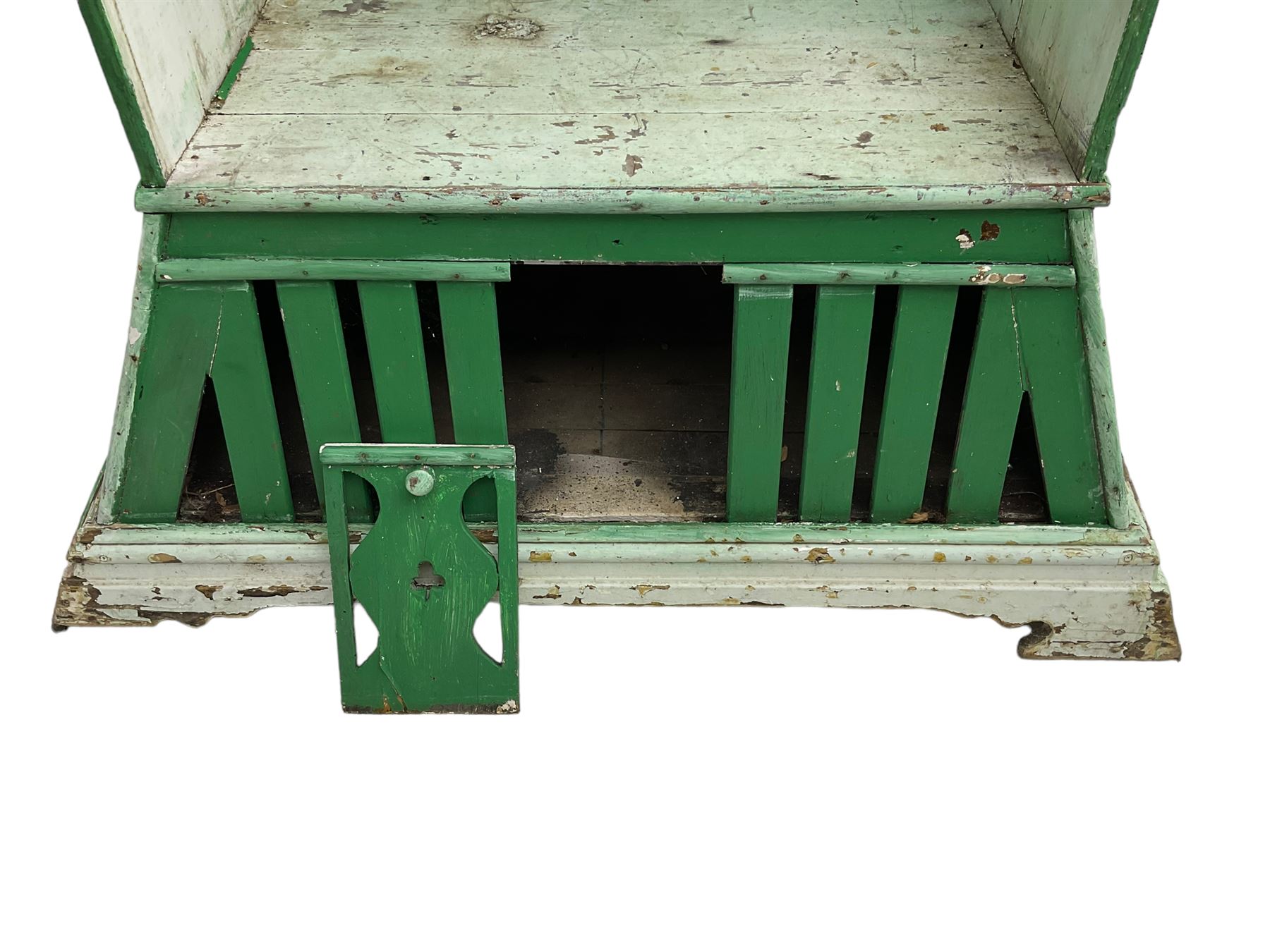 19th century painted pine hen coop settle, overhanging arched canape with dentil moulding and shaped edge, the panelled seat over a triangular platform base with removable hen-coop door, in green and white finish