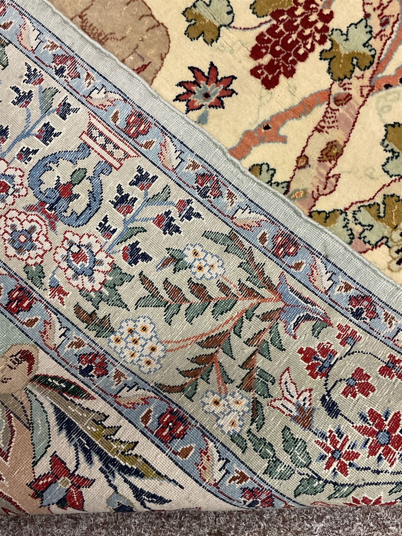 Fine Persian tree of life rug wall hanging, ivory ground field depicting landscape filled with animals, birds and flowers, the guarded border with stylised flower heads and foliage decoration, with brass hanging rail