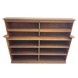 20th century oak double bookcase, ten shelves fitted with hinged spine covers, on moulded plinth base