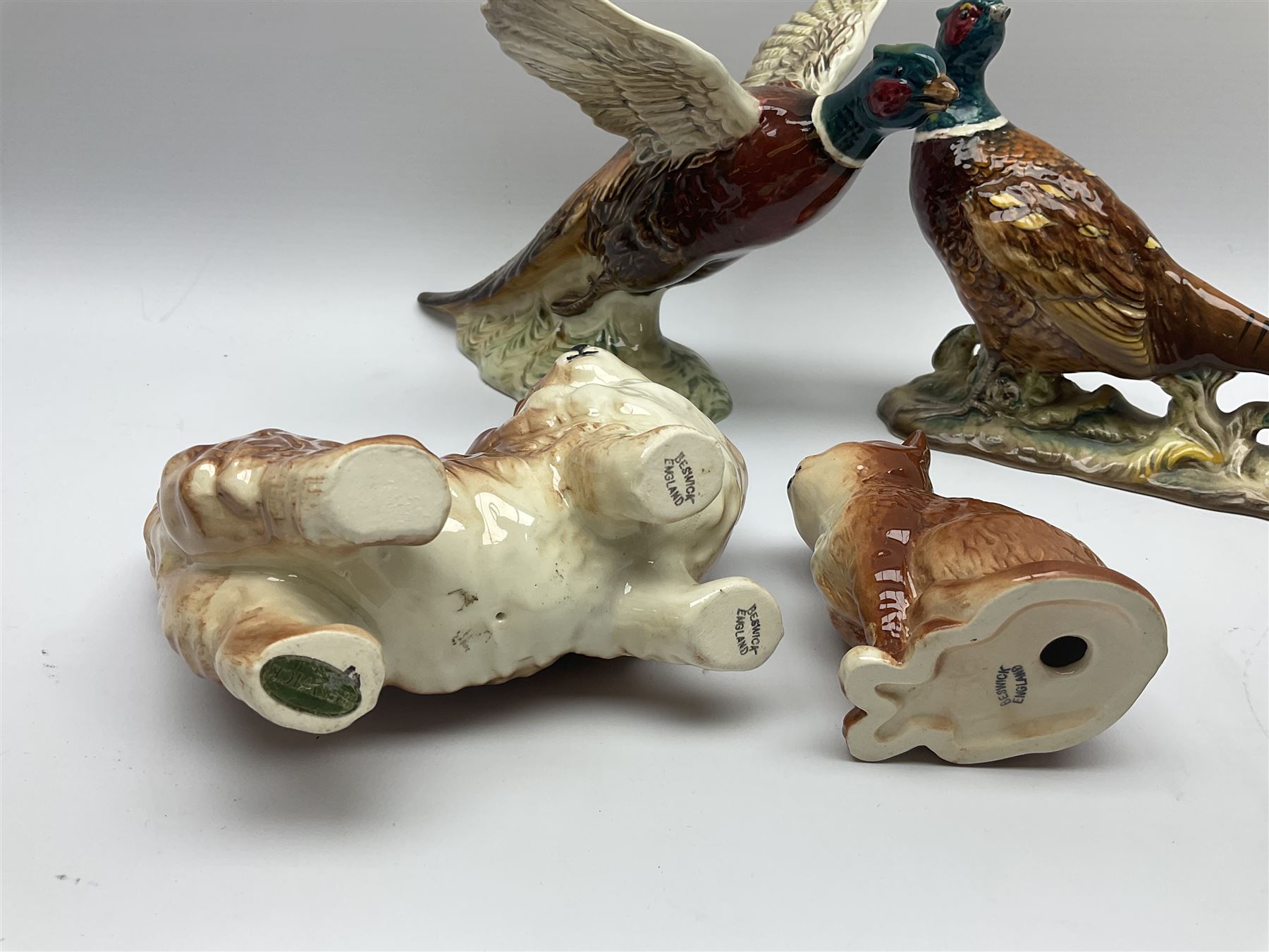 A collection of Beswick figures, comprising ginger cat model no 1898, ginger Persian kitten model no 1886, pheasant in flight model no 849, and pheasant model no 1226b.  
