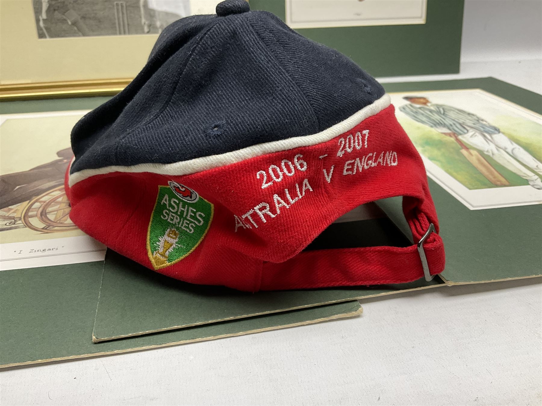 Cricket interest; signed original photograph of 1956 England V Australia Test match, cricket cap from England/Australia Test Match 2006 in Melbourne, eight coloured cricketing spy prints in mounts 