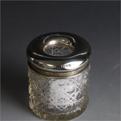 Edwardian silver fall-front ring box with loop handle, opening to reveal velvet interior with five ring spaces, hallmarked Deakin & Francis, Birmingham 1907, together with a cut glass jar with silver lid inscribed 'Hair Tidy' and a silver mounted capstan inkwell, both hallmarked 