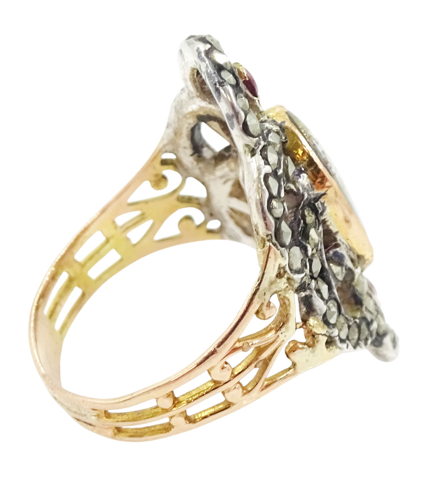19th century gold and silver marcasite portrait ring, set with an oval miniature of a woman on ivory, under a glazed panel, with a marcasite and red stone set crossover surround, with pierced gold shoulders and reeded shank. This lot has been registered for sale under Section 10 of the APHA Ivory Act
