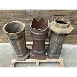 Collection of three Victorian and early 20th century reclaimed terracotta chimney pots, comprising: one cylindrical form with weathered, cracked glaze and flared octagonal base; one deep red cylindrical pot with fluted midsection and castellated rim, bearing moulded number ‘25’; and one tapering hexagonal example with wide flared rim and weathered patina. All with age-related wear and chips, consistent with use and outdoor exposure. Plus a selection of cast stone pieces including fountain 