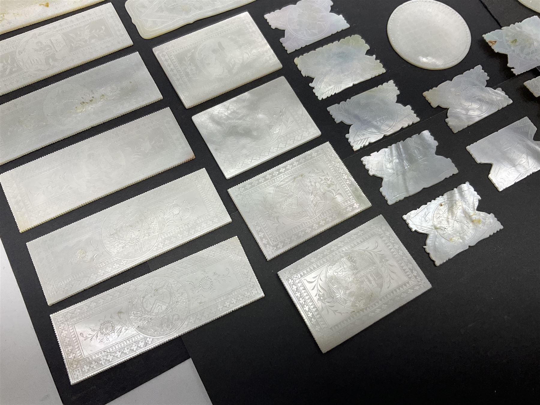 Collection of fifty seven Chinese mother of pearl gaming counters or tokens, of various size and form including rectangular, circular and fish shaped examples, various decoration including floral motifs, largest rectangular examples L6cm