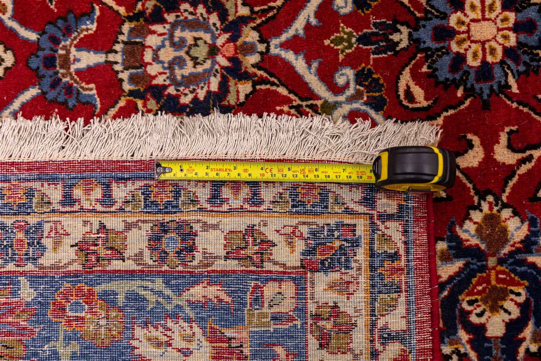 Central Persian Markazi Mahal hand-knotted carpet, terracotta red field, with an all-over scrolling vine design issuing with palmettes, rosettes, and serrated leaves, linked by ivory vinery, deep cobalt blue main border with floral ornamentation, flanked  by multiple guard stripes of repeating geometric motifs, with cotton fringe ends