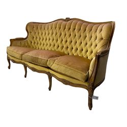 Late 20th century beech framed three seat settee, shaped back carved with flower heads, upholstered in buttoned fabric, on cabriole supports 