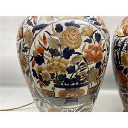 Pair of large and impressive 20th century Japanese Imari table lamps, each of ovoid form, decorated in the Imari palette with roundels containing flowering urns, and shaped panels of birds, set against a white ground decorated with blossoming peonies, lamp base (not including fixtures) H56.5cm overall including shade H89cm