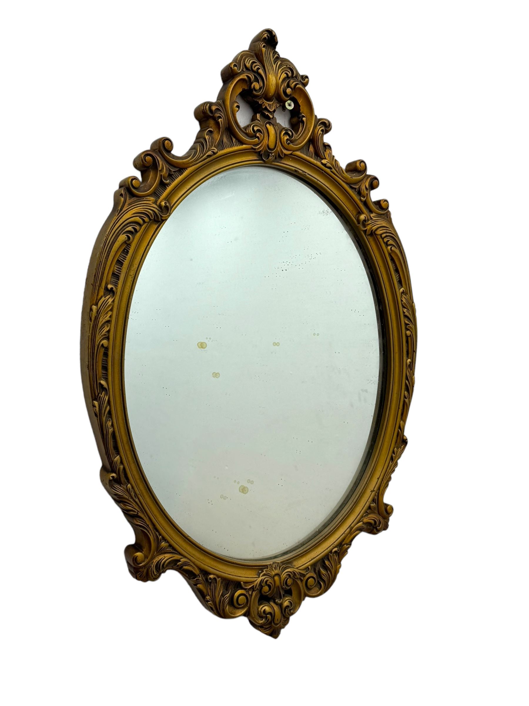 Giltwood oval wall mirror with carved Rococo-style frame, scrolling acanthus leaves and pierced crest (H71cm); smaller oval mirror with floral pattern and openwork scrolls, surmounted by a rose crest (H54cm)