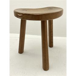 'Mouseman' oak three legged stool with dished kidney shaped seat, tapered octagonal supports, with carved mouse signature, by Robert Thompson of Kilburn 