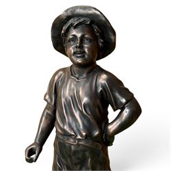 Bronzed composite figure of a boy wearing a hat, on circular plinth