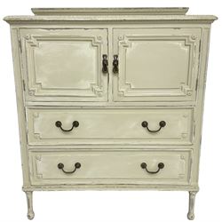 Early to mid-20th century painted tall boy, the raised back decorated with vertical reeded and oval bead motifs, foliate moulded rectangular top over double cupboard and two drawers, decorated with geometric mouldings and flower heads, on turned and reeded feet, in distressed cream paint and waxed finish  