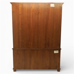 Late 20th century oak bookcase on cupboard, with moulded cornice above pair of astragal glazed doors with shaped inner frames enclosing adjustable shelves, the base with moulded top above two fielded panel cupboard doors with brass handles, upon compressed bun front feet 