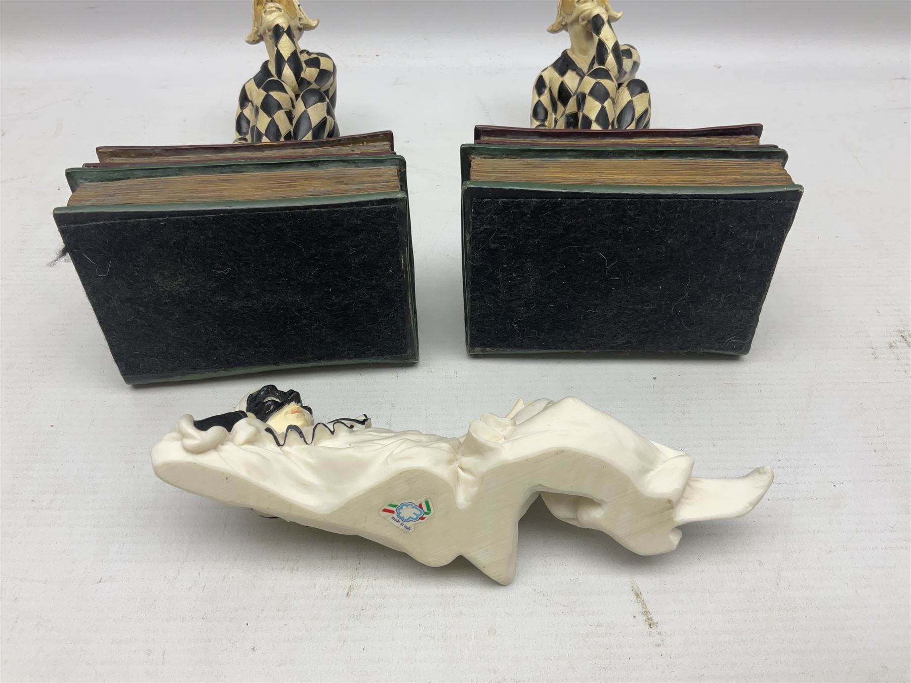 Pair of early-mid 20th century figural composite bookends modelled as harlequin court jesters sat upon stacks of books, H20cm together with a figure of a jester signed Vivian C (3)