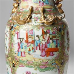 Cantonese famille rose vases, of inverted baluster form, the domed cover with gilt dog of Fu finial, H38cm; together with a further pair of Cantonese vases, each with double Buddhist lion handles and applied at the shoulders with chilong, H45cm (3)