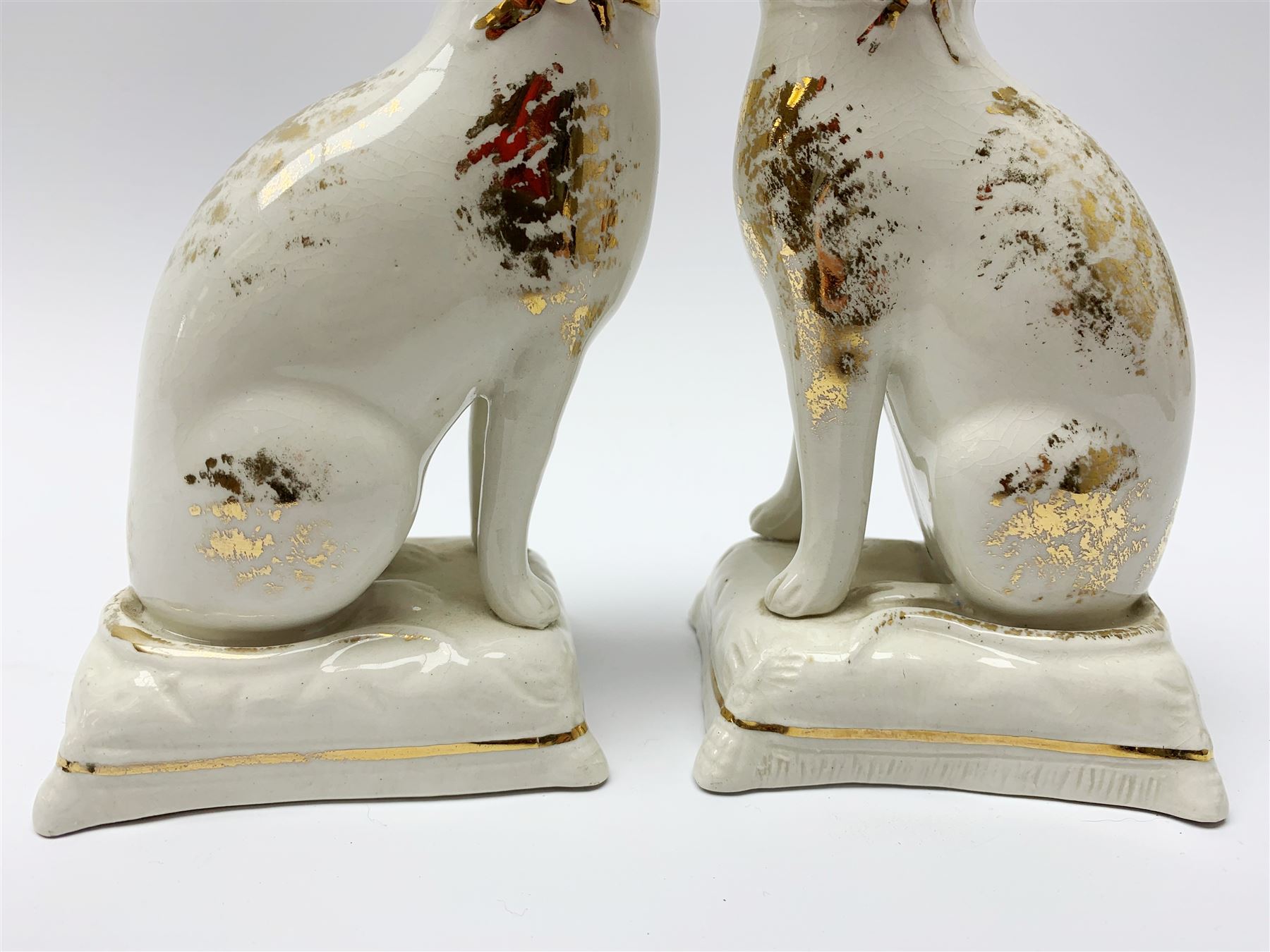 Pair of Victorian Staffordshire cats, modelled seated upon cushions, with gilt detail throughout, H18cm