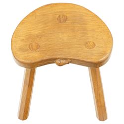 Mouseman - oak three-legged milking stool, dished kidney-shaped seat, raised on three octagonal splayed supports, with carved mouse signature, by the workshop of Robert Thompson of Kilburn