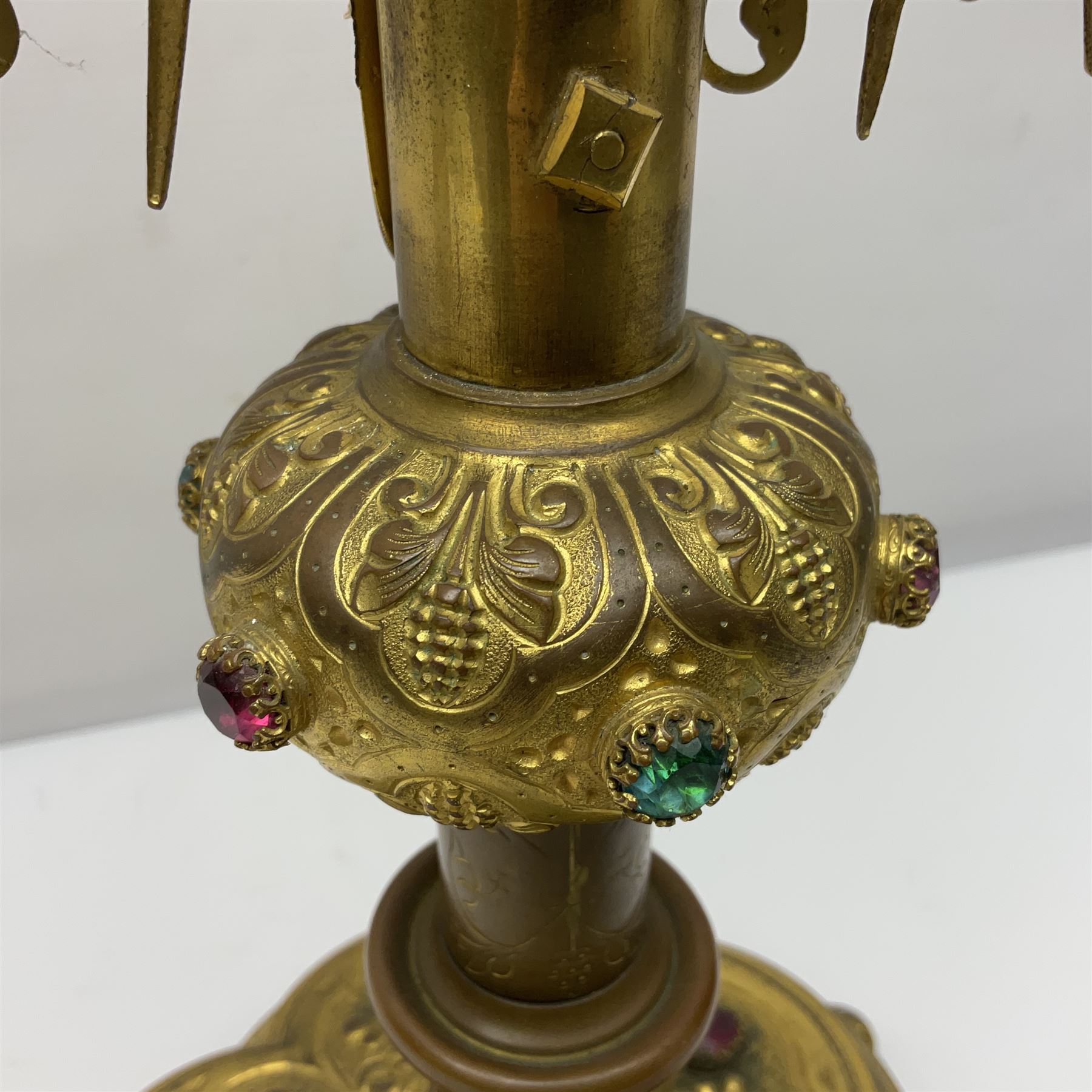 20th century gilt metal monstrance, in the Gothic revival style, with glazed aperture to centre surrounded with clear paste stones, in a pierced floral and scroll border set with coloured paste stones, within a sunburst surround, on a paste set knopped stem and similar foliate foot, H59.3cm