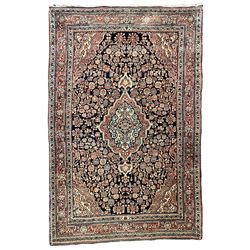 Persian indigo ground rug, the field decorated with intricate interlaced foliage branches and small flower heads, shaped floral design central medallion, the border decorated with scrolling branch and flower heads within guard bands 