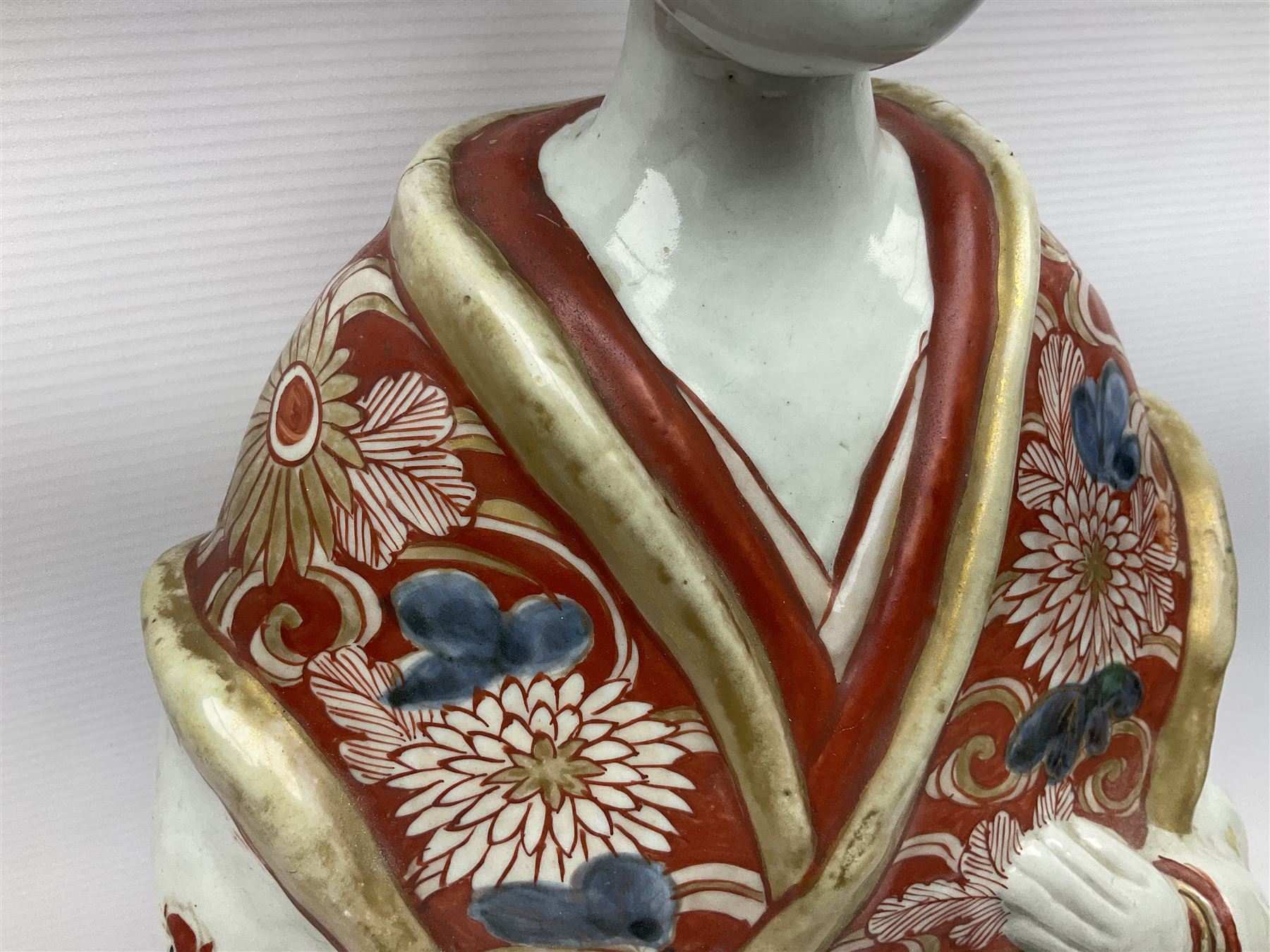 Large Japanese Imari porcelain figure, modelled as a Bijin, wearing a long kimono decorated with apple blossom and leafy branches on a white ground, with gilt detailing, possibly Edo period, H63cm