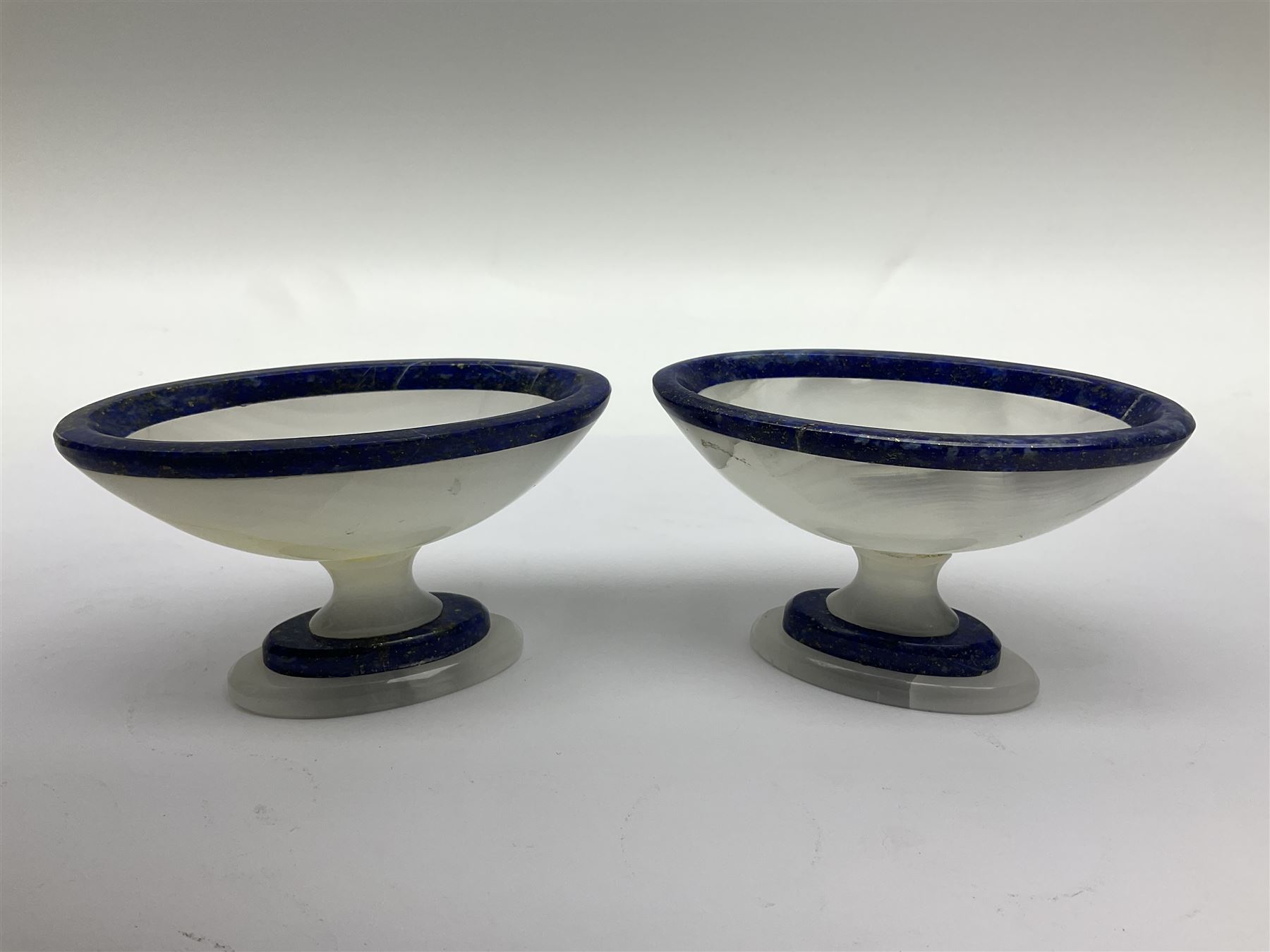 Pair of lapis lazuli and agate open salts, of navette form, upon a stepped oval pedestal foot, H5cm, L8cm