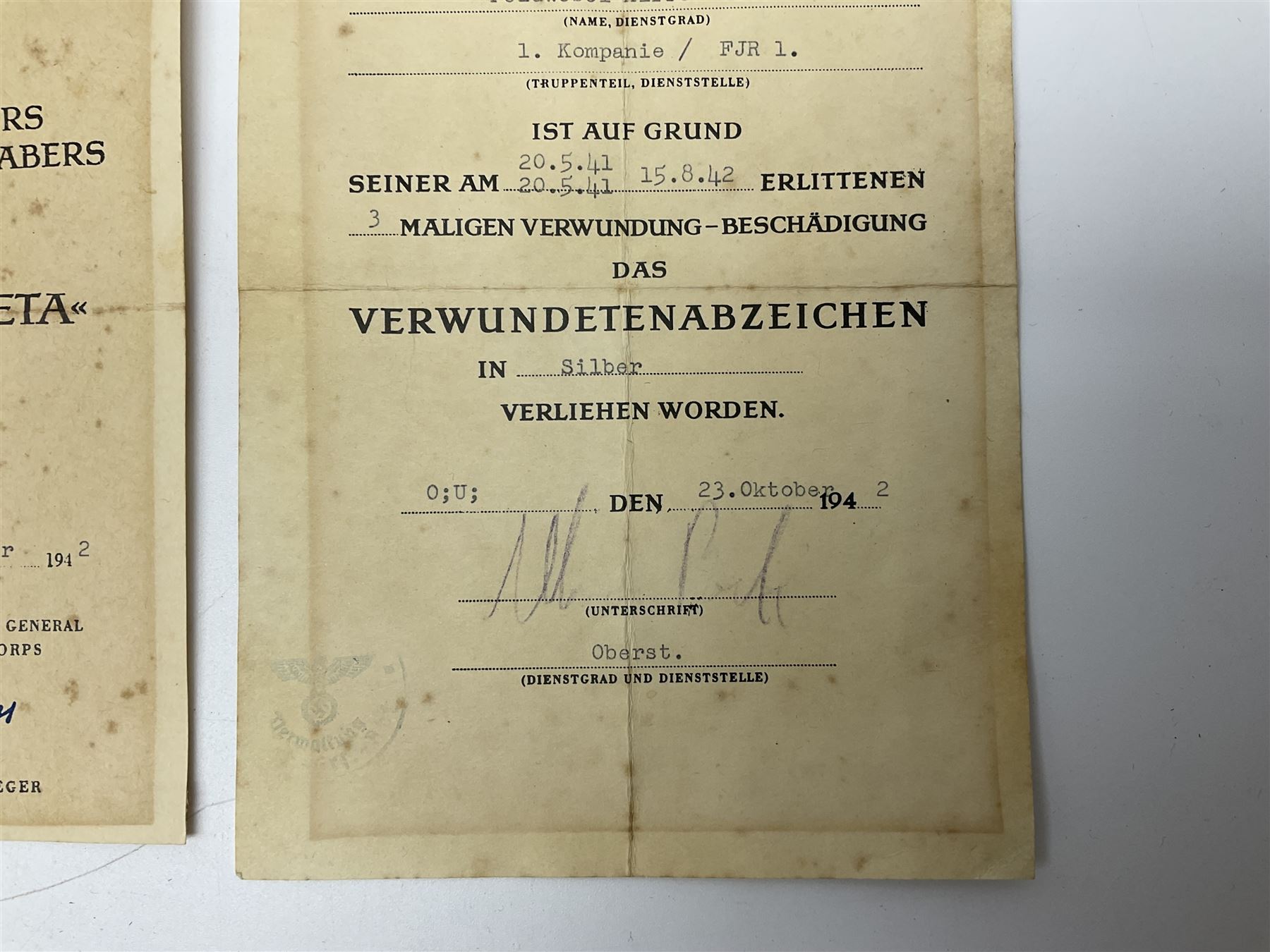 Three German documents dated 1942 - Gold Cross award to Major Ludwig Osterkampf; and Crete wound certificate and cuff title certificate awarded to Feldwebel Alfred Glaise; all unframed (3)