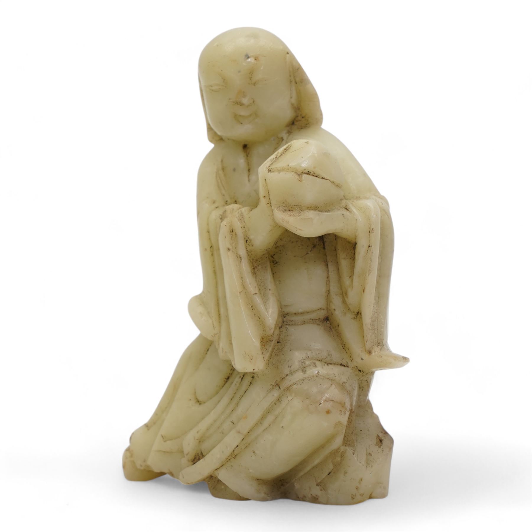 Chinese blanc de Chine figure of Guanyin, wearing robes and standing upon a lotus base, H25.5cm, a jichimu carved wooden stand, and carved greenstone figure of an immortal (3)
