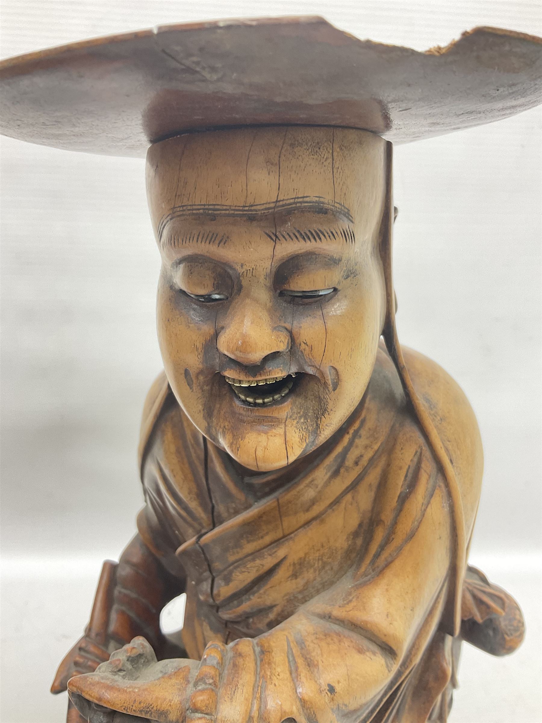 Pair of Japanese carved wooden figures, modelled as merchants in traditional dress, upon pierced naturalistic bases, tallest H39cm