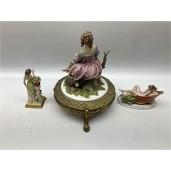Capodimonte figurine of a lady seated upon a tree stump reading a book, raised on an Ornate Bronzed Metal Stand, together with two other Capodimonte figures, tallest example H34cm