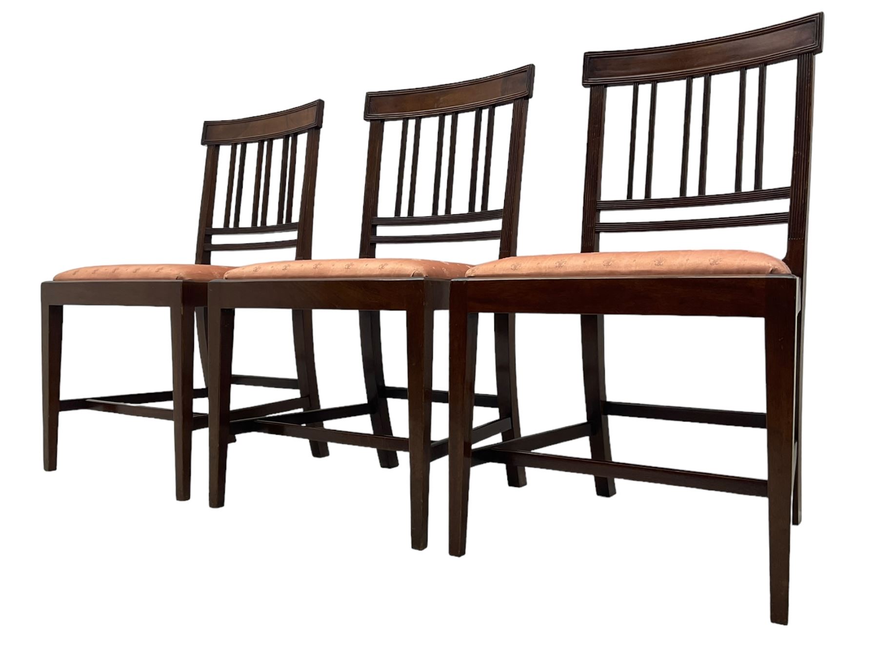 Early 20th century Regency design mahogany tilt-top table, circular top with edge banding, supported by a central turned pedestal with four reeded sabre supports terminating in castors; six chairs with pink upholstered drop in seats (7)