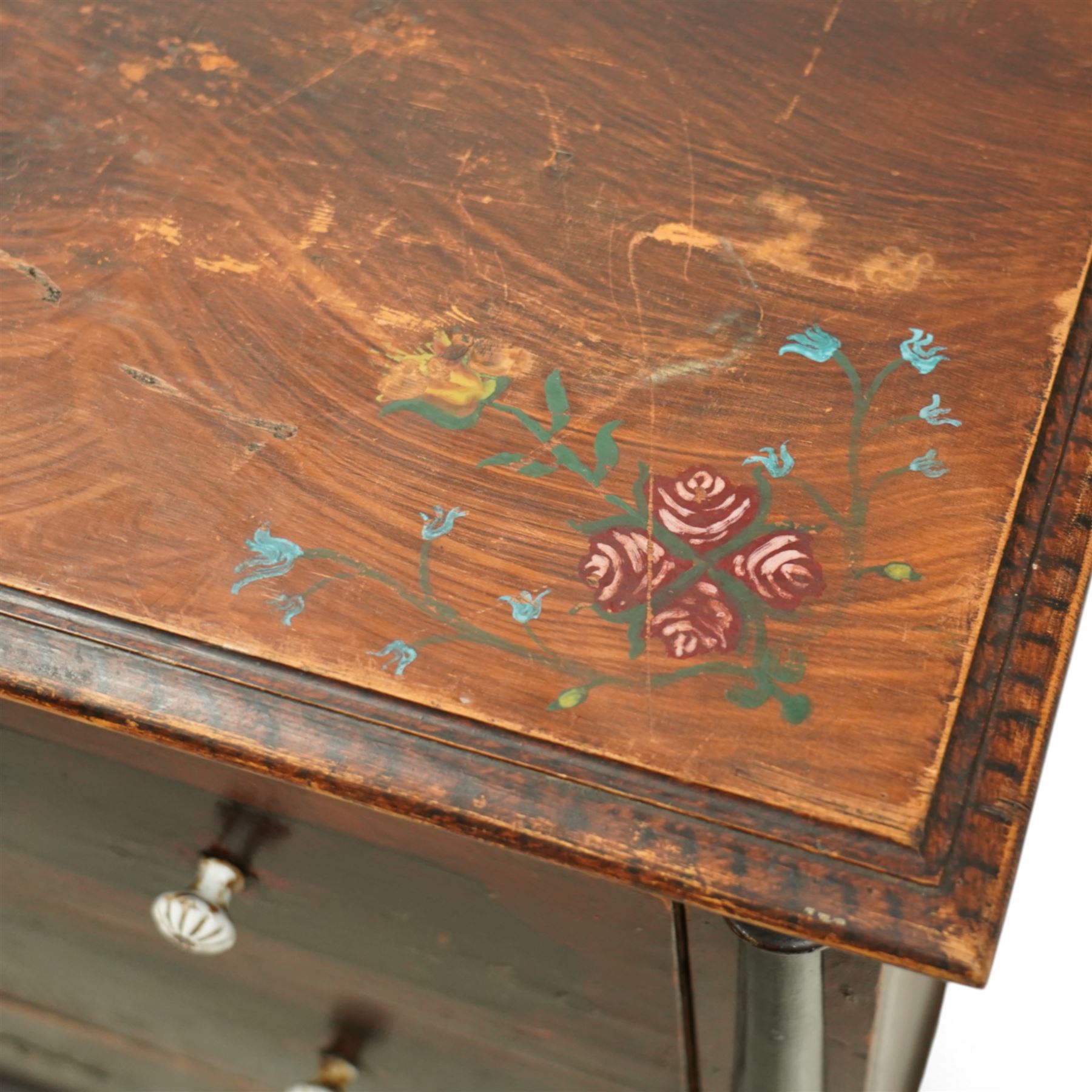 19th century painted pine chest of drawers, the rectangular top with moulded edge and painted floral decoration, above three drawers with later ceramic handles, with half turned column and reeded pilasters, upon turned compressed bun feet  