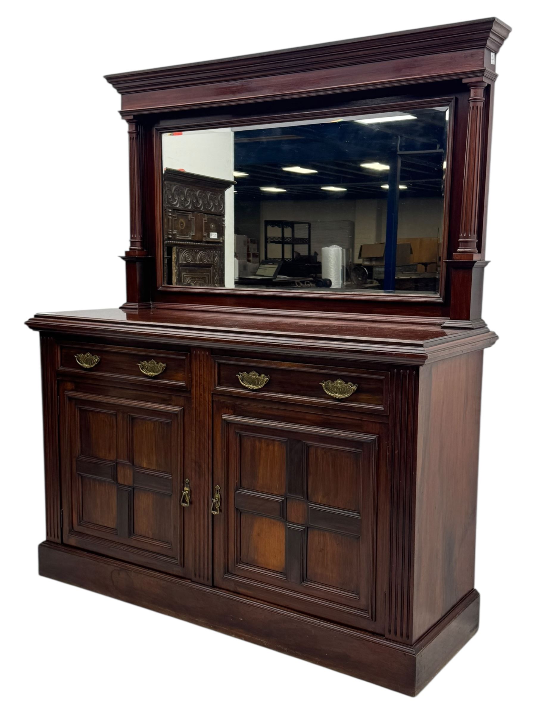 Victorian mirror back press, the arched corniced mirror back flanked by half columns, the base fitted with three drawers and four moulded panel doors with geometric detail, on a block plinth