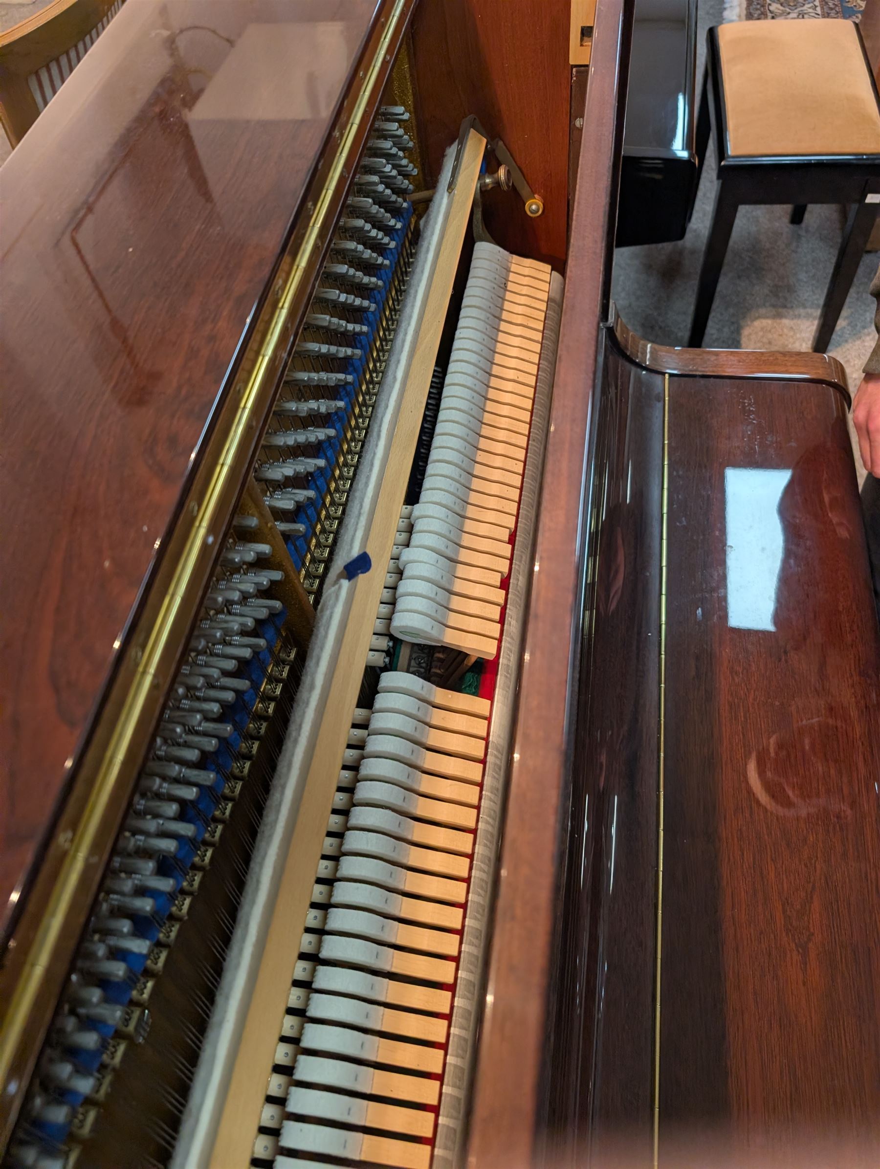 Bluthner of Leipzig upright piano, mahogany case with 88 keys and three brass pedals