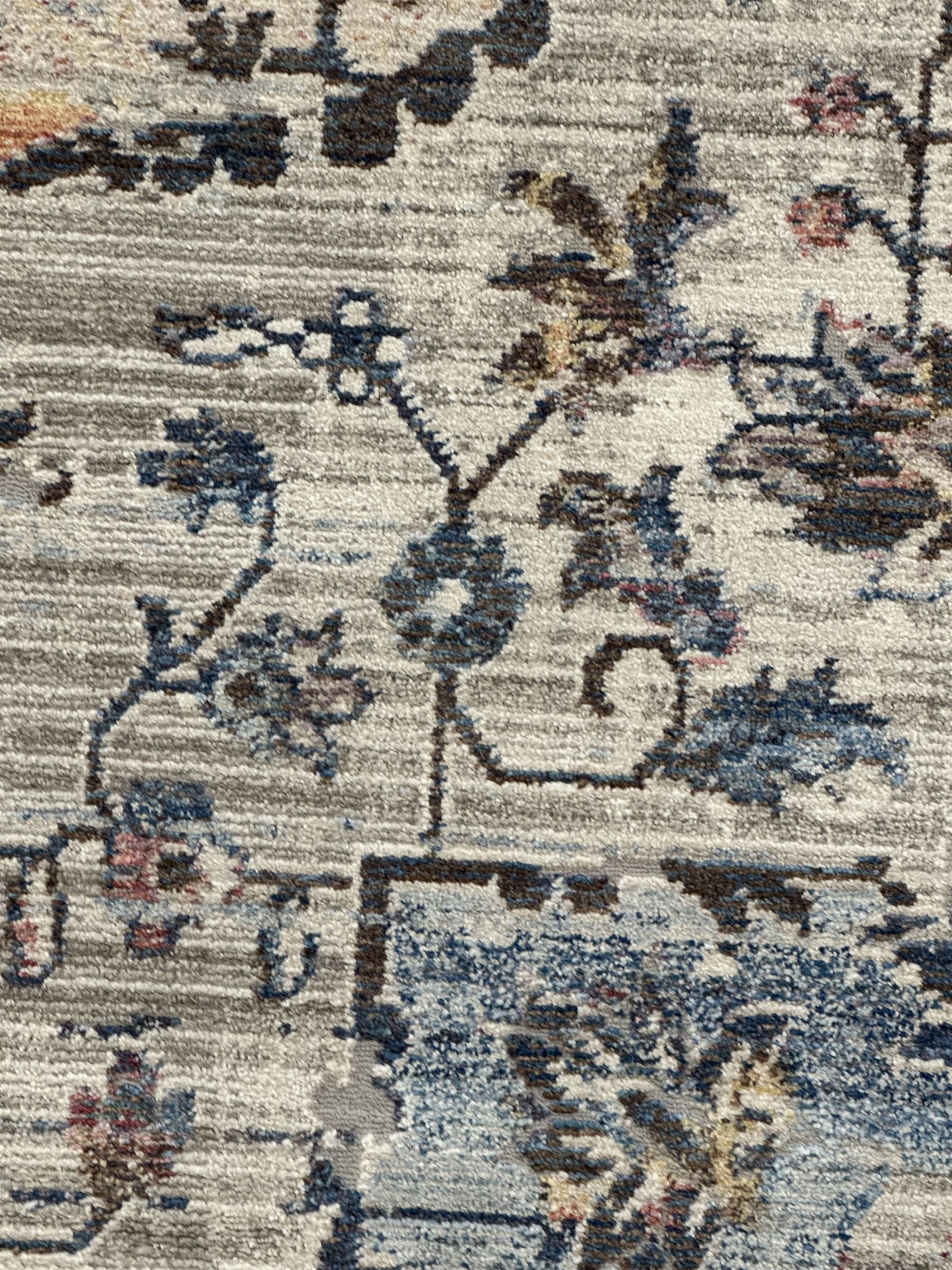 Contemporary Dunelm Soraya Persian design rug, blue and beige ground with faded floral and vine motifs, central medallion and trailing foliate patterns, bordered by a distressed design with stylised floral motifs