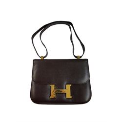  1960s/1970s Hermes Constance brown leather handbag, with shoulder strap and gilt metal 'H' clasp, opening to reveal brown kid leather compartmentalised interior, stamped 'Hermes' to underside of clasp and 'Hermes Paris Made in France' to underside of cover, H19cm, W24.5cm