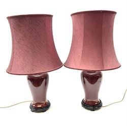 Pair of dark red table lamps in baluster form with a round wooden base, with matching shades, H69cm.  