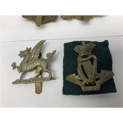 Fourteen cap badges of Irish interest including Royal Dublin Fusiliers inscribed to the slider 'From A. O'Connor 2nd Batt. Dec.2nd 1915', Connaught Rangers, South irish Horse Yeomanry, Inniskilling Fusiliers, Royal Irish Regiment etc; and seven Welsh badges including South Wales Borderers, Welsh Guards, 3rd Bn. Monmouthshire Regt. etc (21)