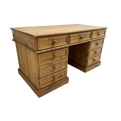 Pine twin pedestal desk, fitted with nine drawers, on plinth base