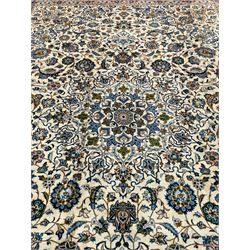 Persian Kashan ivory ground carpet, the interlaced foliate medallion surrounded by trailing plant motifs interlaced with scrolls, the guarded border with repeating stylised flower heads