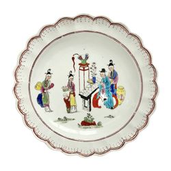 18th century Worcester Chinese Family pattern plate, circa 1765, of circular form with scalloped rim, the dished centre decorated in polychrome enamels with figures gathered around a table, within iron red line and dot borders, D19cm