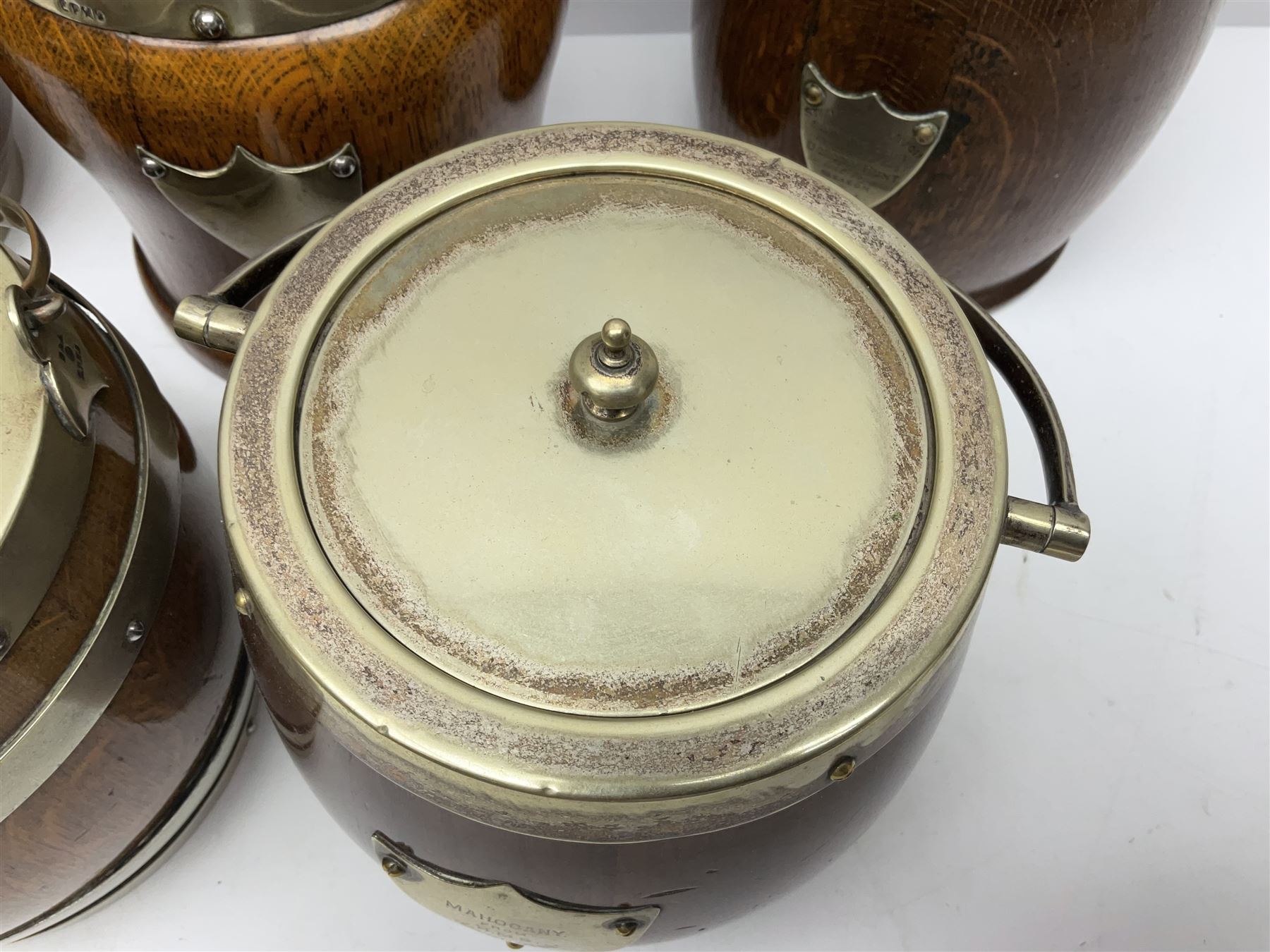 Five early 20th century biscuit barrels with silver-plated mounts, one made from Mahogany from HMS Hindustan