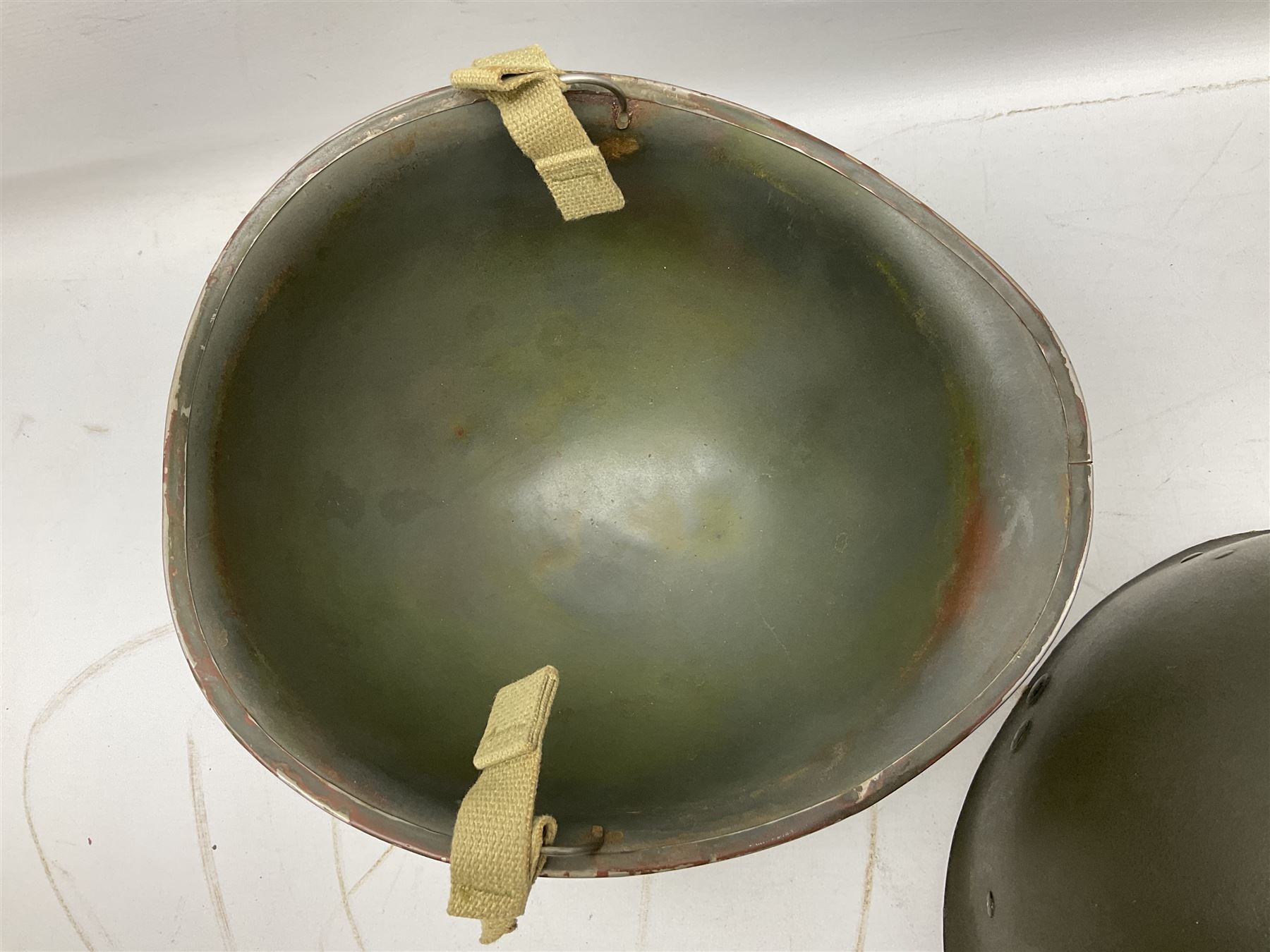 American first type paratrooper helmet with post-WW2 strap and D-rings and later 1944 liner bearing Firestone Tyre and Rubber Company mark; green textured finish