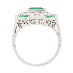 Platinum emerald and diamond milgrain set dress ring, single octagonal cut emerald of 2.40 carat, surrounded by single cut diamonds and a border of calibre cut emeralds, with fancy pierced design gallery diamond and engraved flower head shoulders, stamped 850 Plat