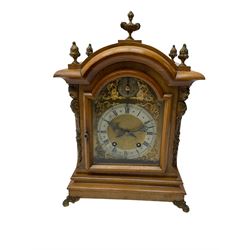 German - 19th century 8-day walnut bracket clock, striking the quarters on two coiled gongs, case with a break-arch top surmounted by cast brass finials, canted corners to the front with cast brass caryatids and sound frets to the sides, brass break arch dial with a silvered chapter ring, steel gothic hands, spandrels, and pendulum regulation dial. With pendulum.