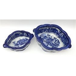 Two Victoria Ware blue and white footbaths, each with twin lug handles and transfer print decorated with city scape, each with printed mark beneath, largest not including handles L34cm, smaller not including handles L25cm.
