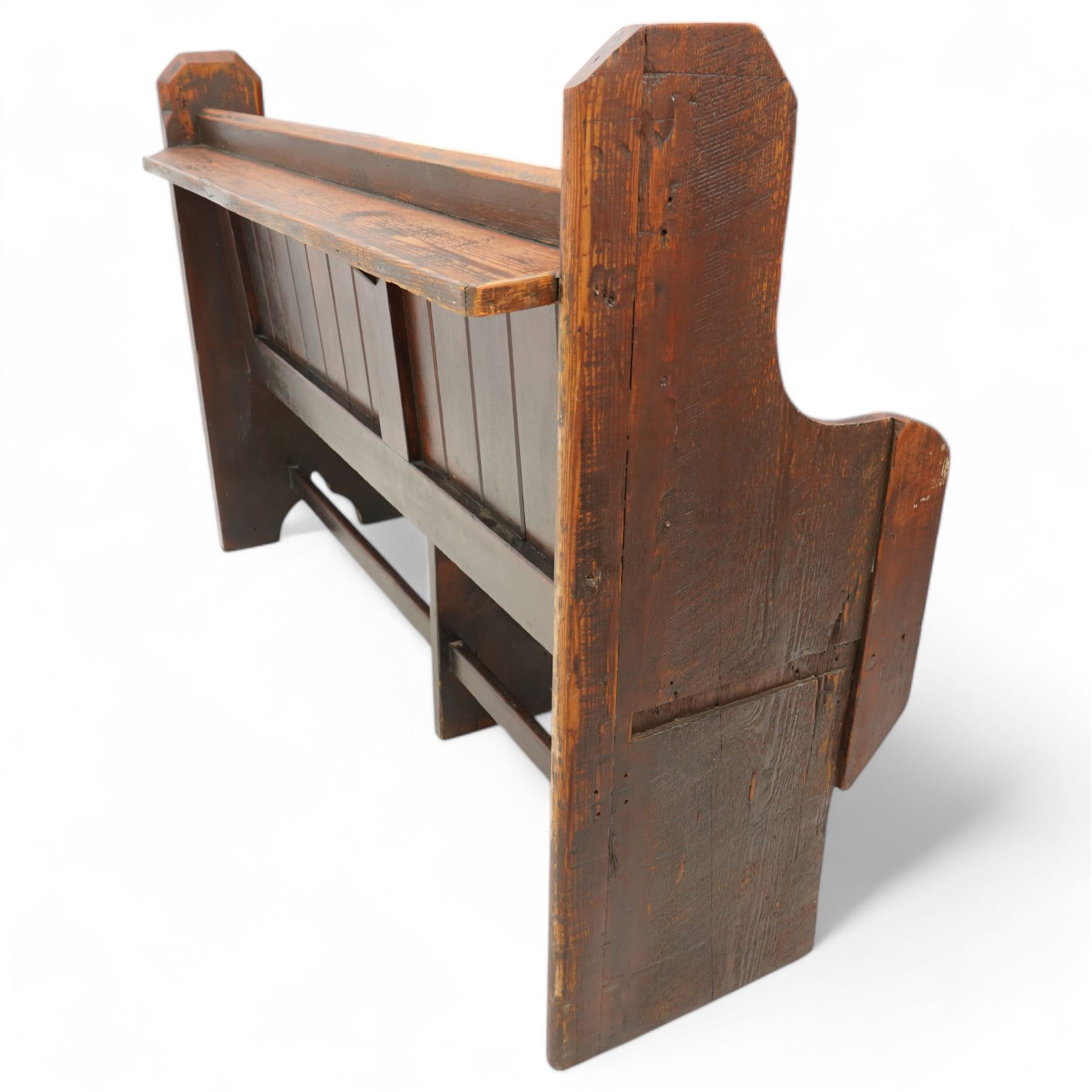 Victorian pine pew or bench, panelled back with book raised over plank seat, on shaped end supports united by stretcher 