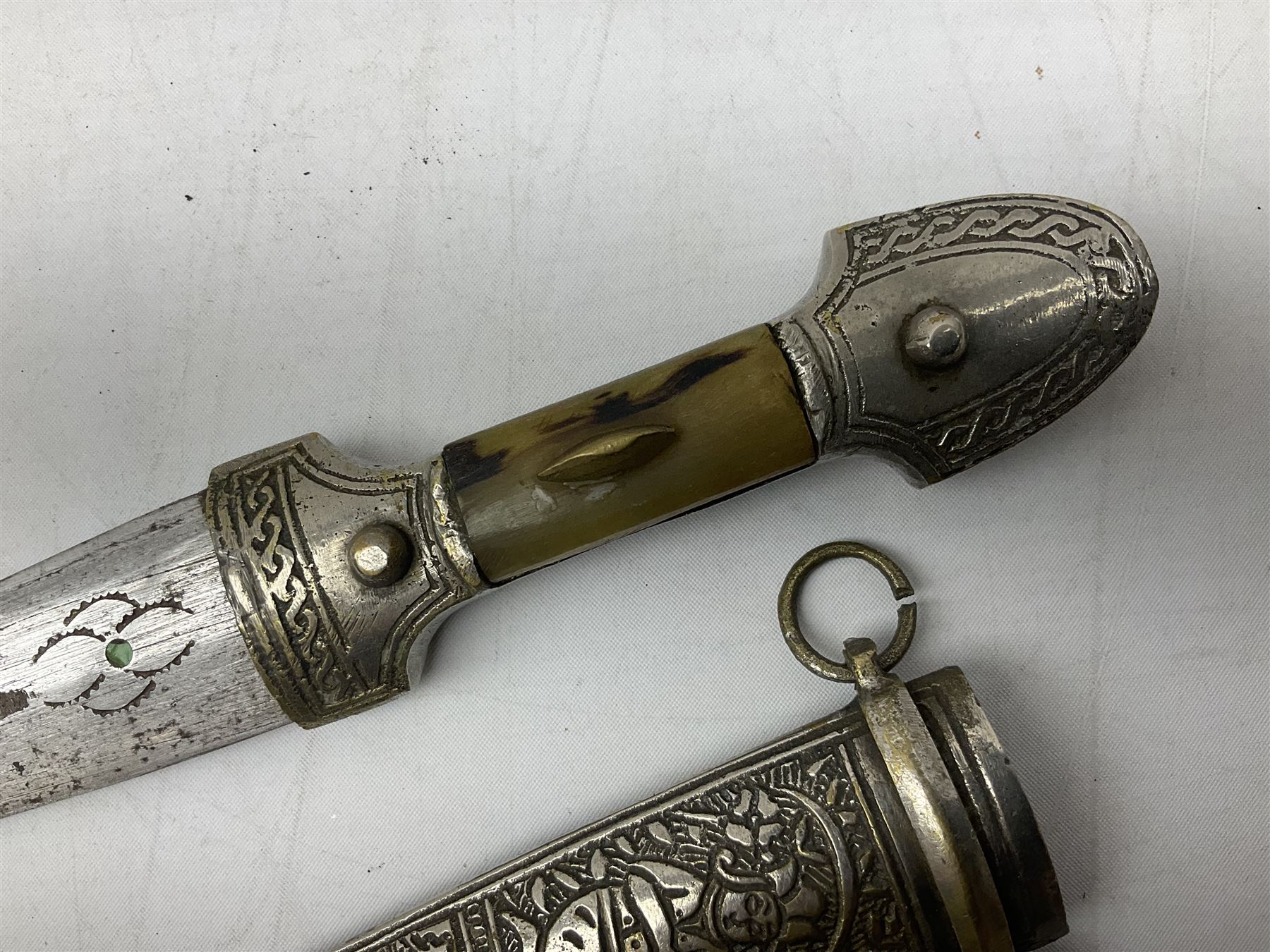 Caucasian qama or kindjal dagger, the 15cm pointed double edged blade with  centre fuller and two-piece horn grip; in nickel plated scabbard with  panels of figures and script L28.5cm overall; and east 