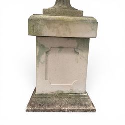 Pair of weathered cast stone Neoclassical design garden Kylix shape urns, foliate moulded rim over a gadrooned underbelly, the scalloped socle over a rectangular pedestal with faux-panelled sides, stamped with stylised ‘H’ monogram